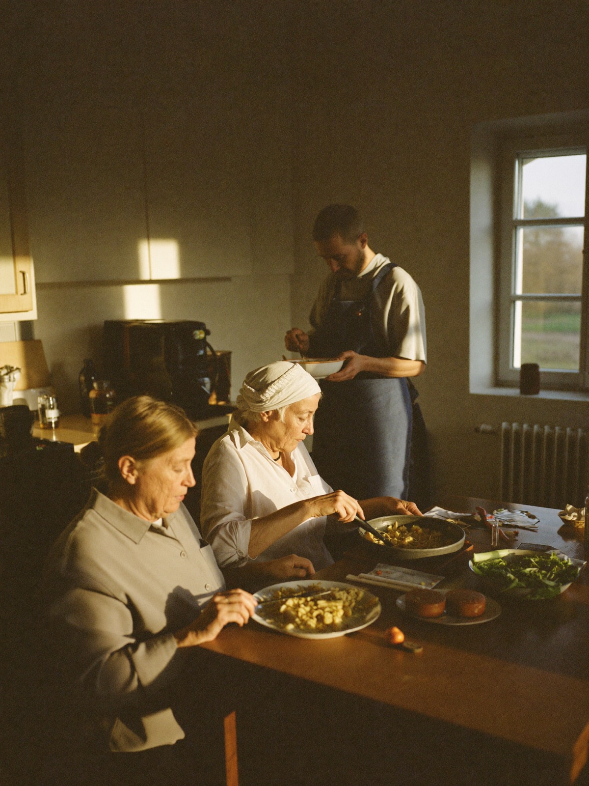 Bewoners en een begeleider koken samen in een huiselijke keuken